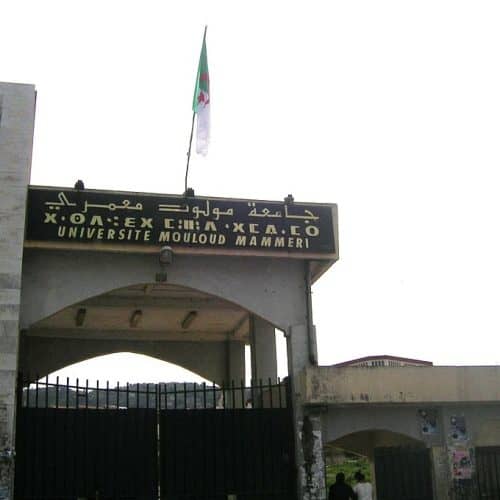 Entrance gate of Université Mouloud Mammeri in Tizi Ouzou, with trilingual signage and an Algerian flag.